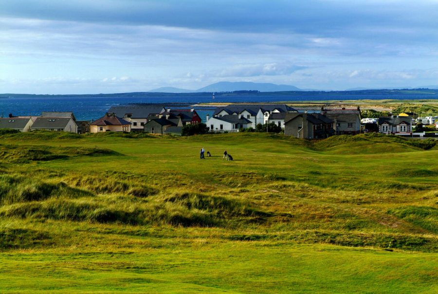 Golfers at Strandhill Golf Club with houses in the background