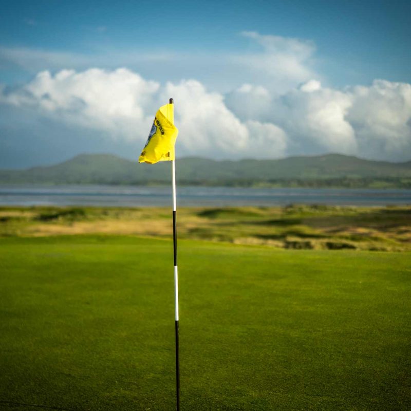 A flagpole standing in the golf course