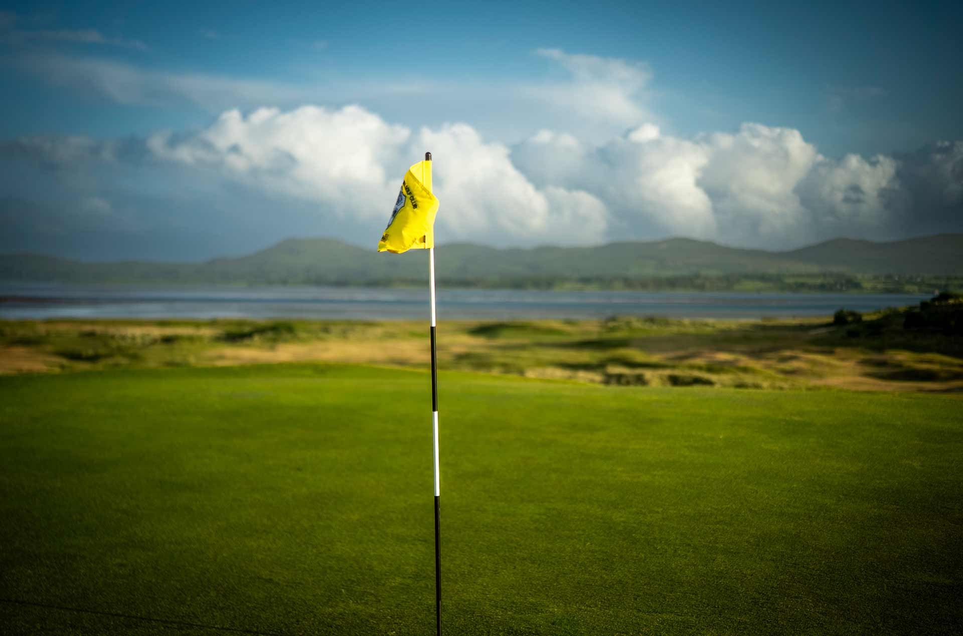 A flagpole standing in the golf course